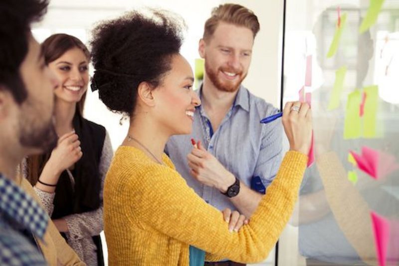 Frau mit Kollegen am Whiteboard